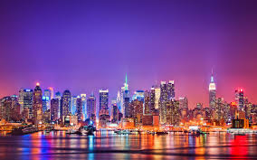 Image of the New York Skyline take across the Hudson River at twilight. THe sky is a hue of purple and pink.